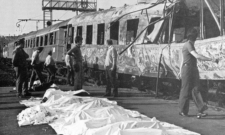 Le vittime della strage disposte davanti al treno Italicus, sventrato dalle bombe.